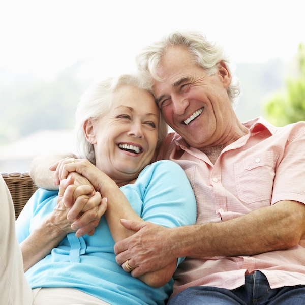 Restorative Dentistry 1 Senior Couple Sitting On Outdoor Seat Together Laughing