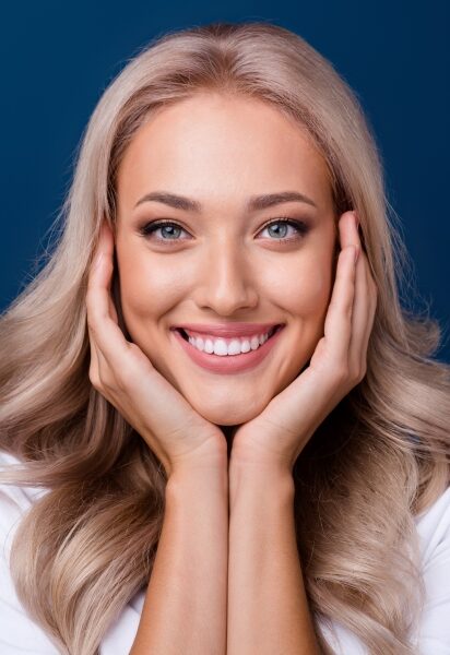 cheerful woman holding face
